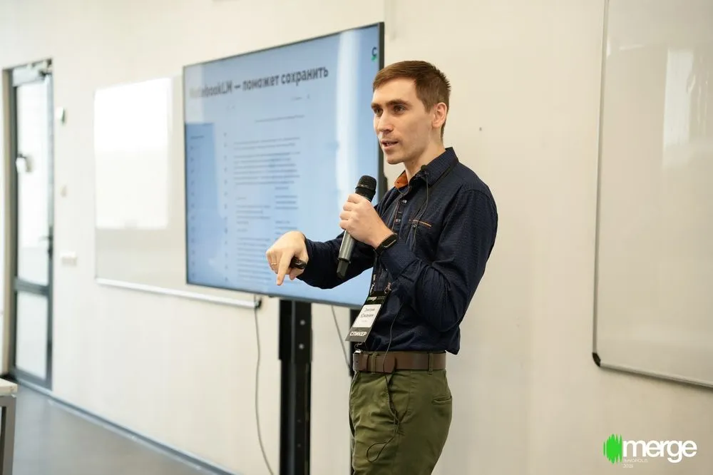 Дмитрий Южанин с микрофоном у экрана на IT-конференции Merge в Иннополисе